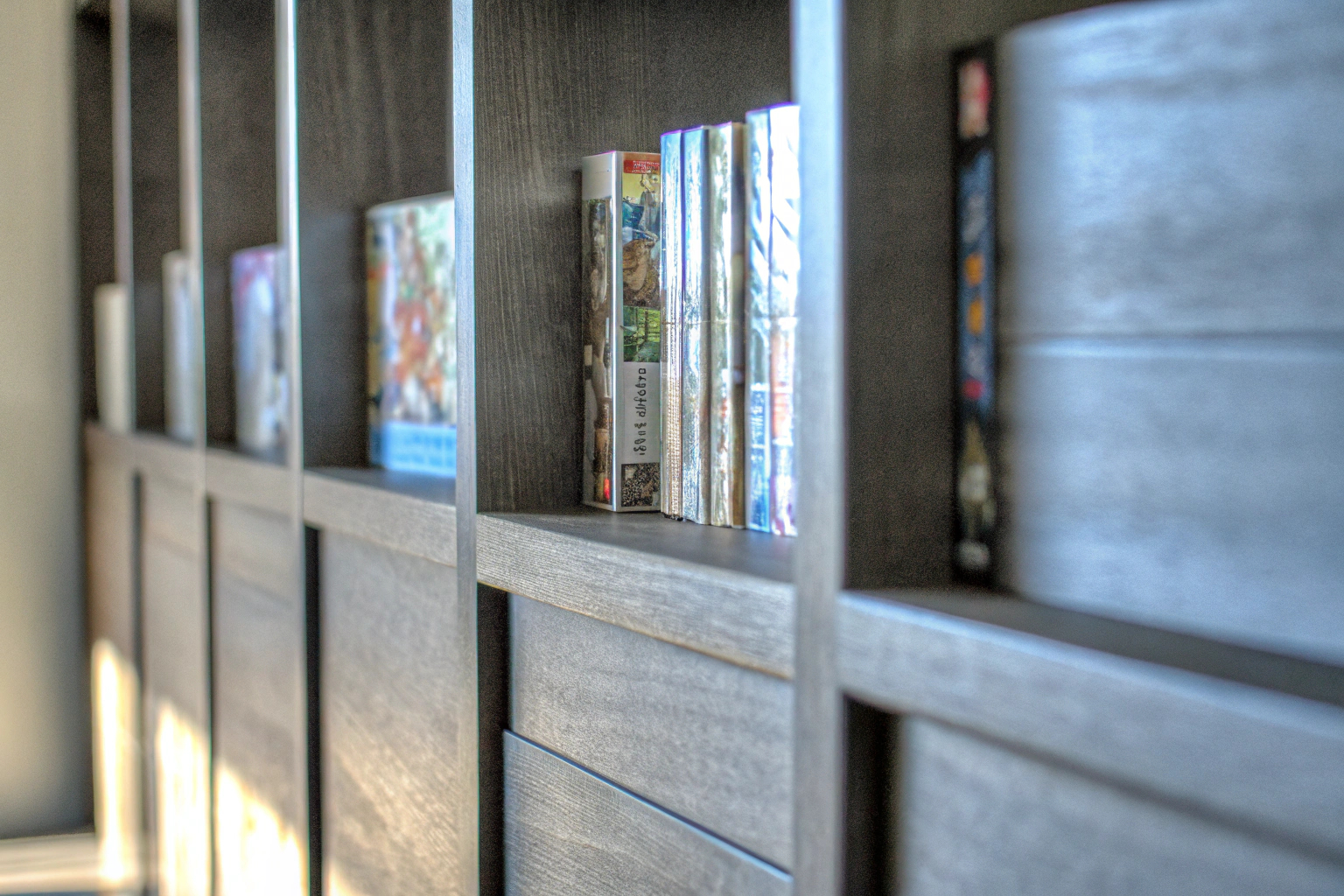 Detailaufnahme eines Spielregals mit einer Vielzahl von Brett- und Kartenspielen, die ordentlich sortiert sind. Spielebibliothek organisiert