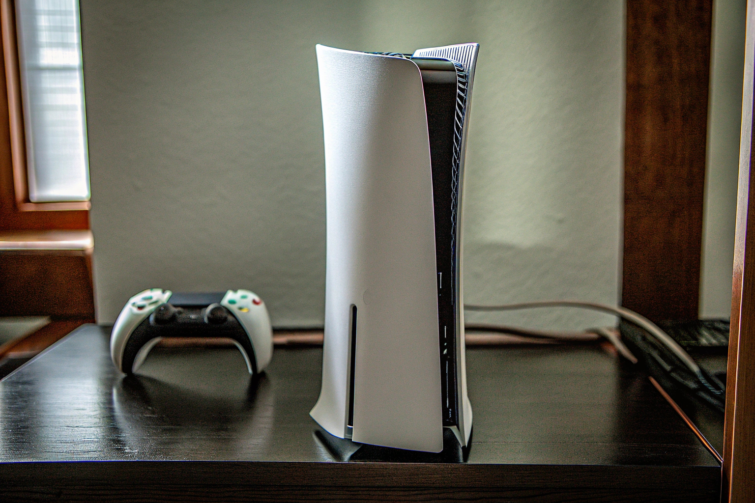 Die PS5-Konsole mit einem vertikalen Standfuß und Staubfilter im Einsatz. PS5 mit vertikalem Standfuß und Staubschutz