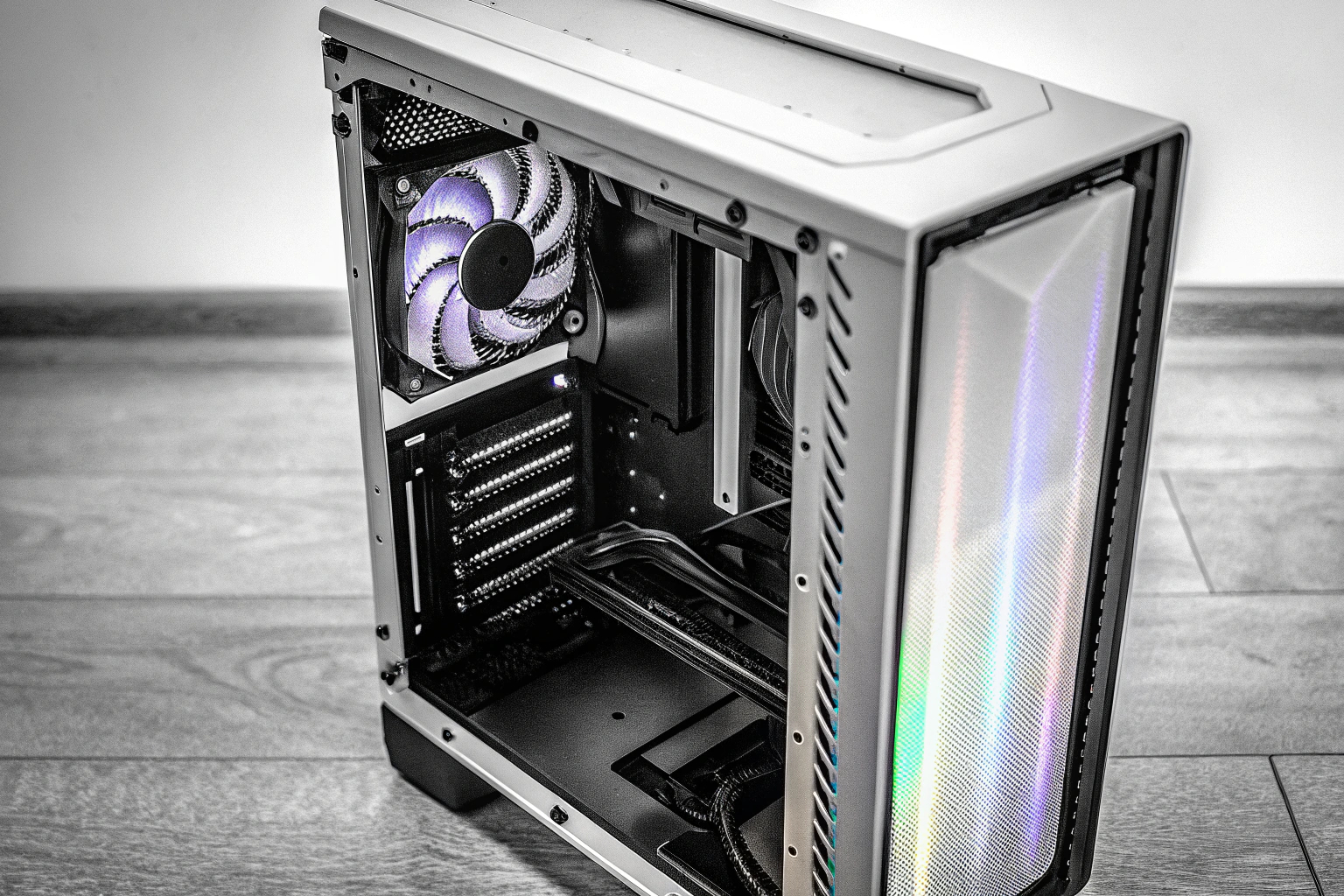 Ein beleuchtetes PC-Gehäuse mit RGB-Streifen, das den Innenraum in verschiedenen Farben erstrahlen lässt. RGB-beleuchtetes PC-Gehäuse