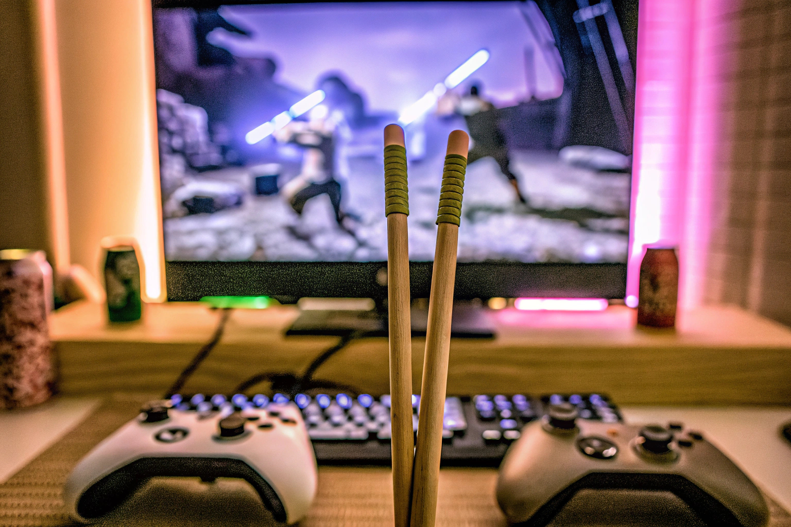 Ein Gamer benutzt Finger-Essstäbchen, während er ein Spiel auf seinem Computer spielt. Gamer benutzt Finger-Essstäbchen