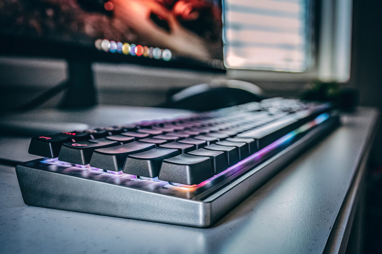 Ein Gamer, der an einem Computer mit einer beleuchteten Gaming-Tastatur spielt. Gamer mit beleuchteter Tastatur