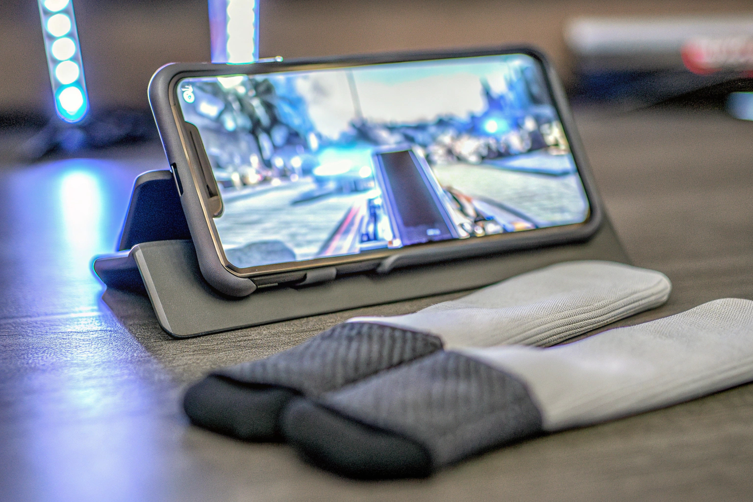 Ein Gamer, der intensiv auf einem Smartphone spielt und dabei Gaming Finger Sleeves benutzt. Mobile Gamer mit Finger Sleeves