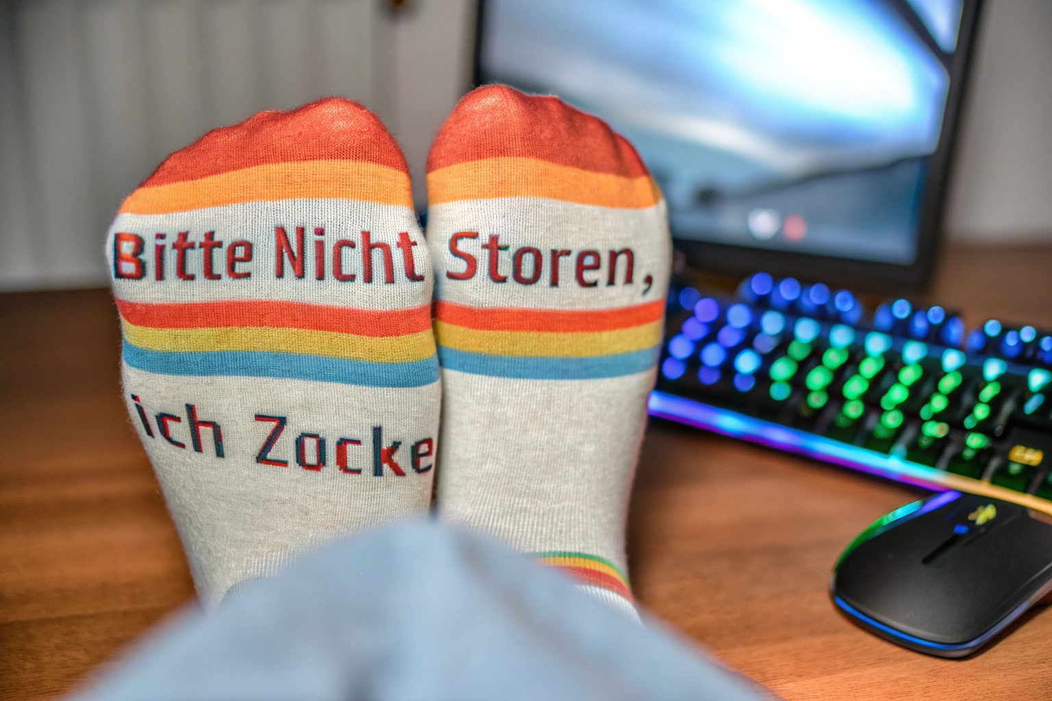 Ein Gamer mit lustigen Socken, die 'Bitte nicht stören, ich zocke' sagen. Lustige Gaming-Socken