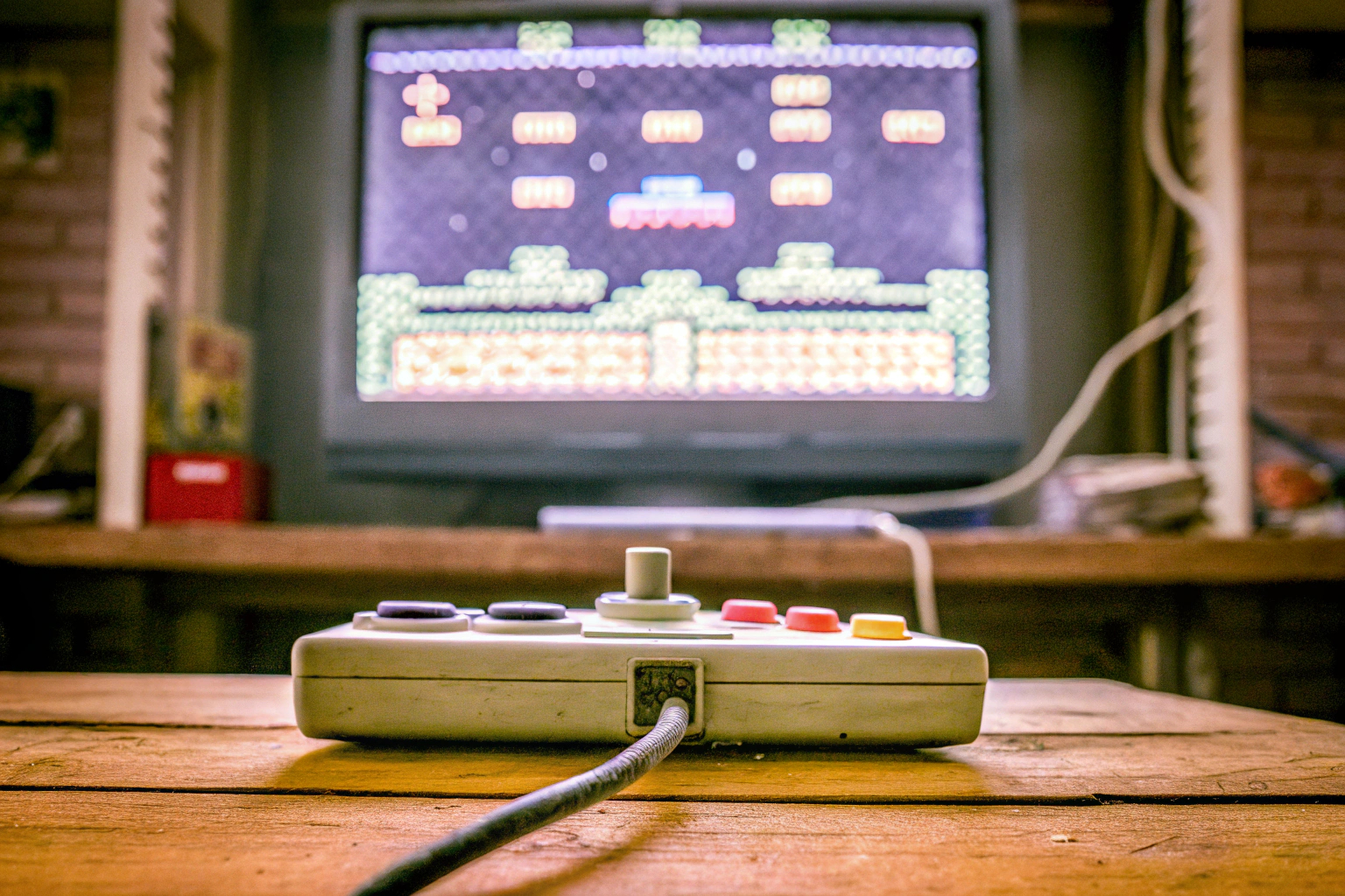 Ein Spieler, der konzentriert auf einen Bildschirm schaut und einen Controller hält, während er ein Retro-Spiel spielt. Gamer mit Controller spielt Retro-Spiel