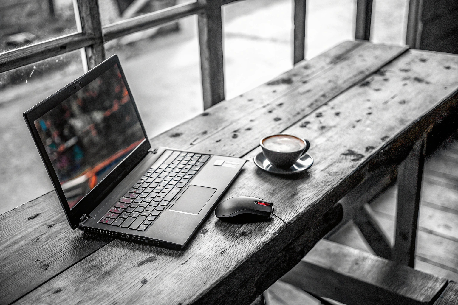 Ein Student, der an einem Gaming-Laptop in einem Café arbeitet. Student mit Gaming-Laptop