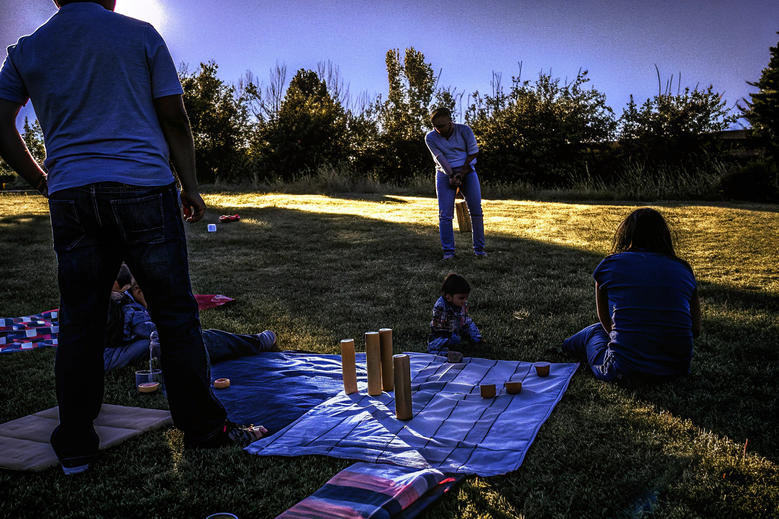 Familie spielt Toyfel Kubb Spiel im Freien