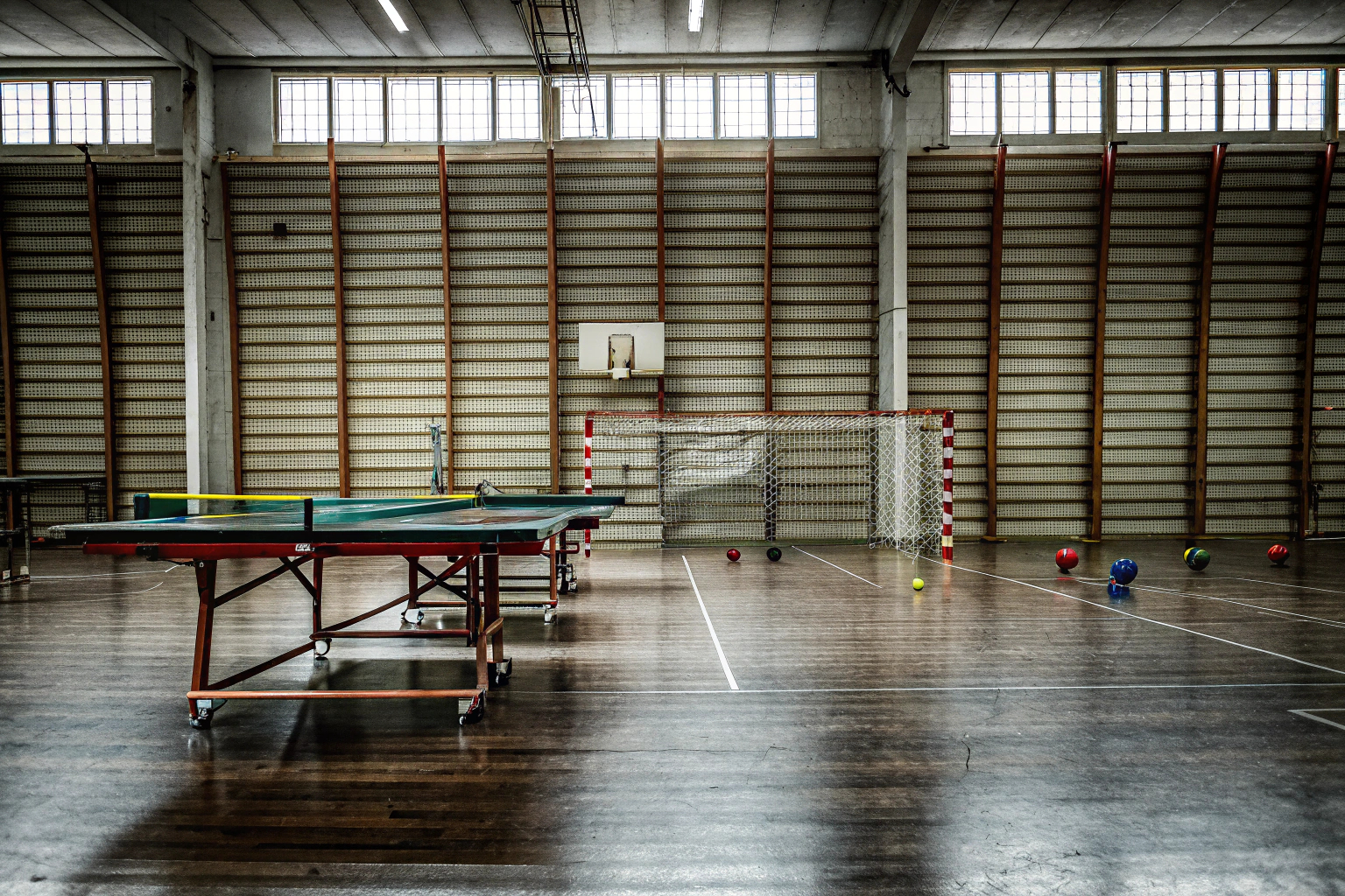 Eine Gruppe von Menschen, die in einer Sporthalle verschiedene Spiele ausprobieren. Menschen beim Ausprobieren von Sportspielen