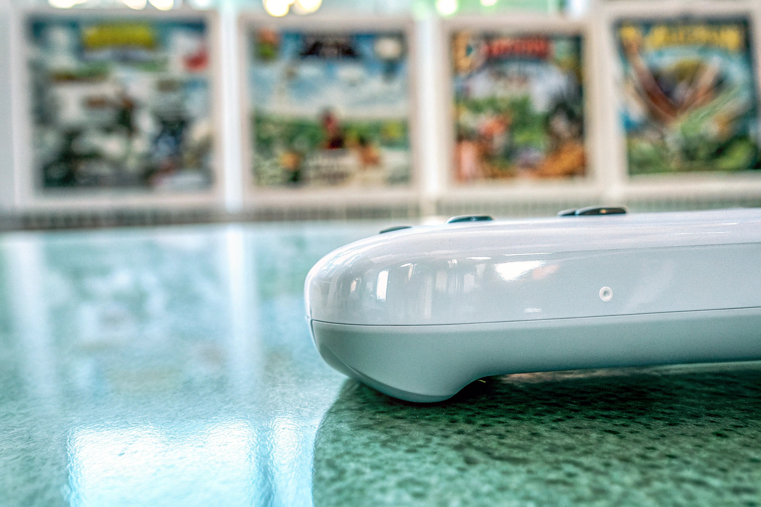 Moderne Spielekonsole mit einem großen Spielesortiment im Hintergrund. Moderne Spielekonsole