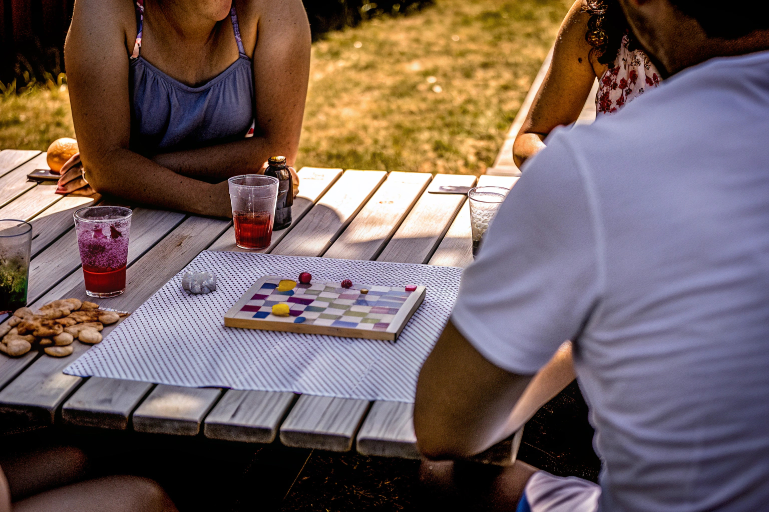 Spieler, die gemeinsam ein spannendes Brettspiel spielen, umgeben von Snacks und Getränken. Geselliges Brettspiel mit Freunden